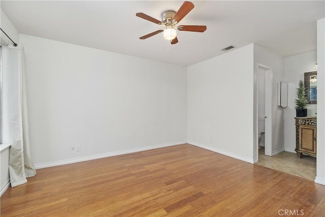 interior space featuring light wood finished floors, baseboards, visible vents, and ceiling fan