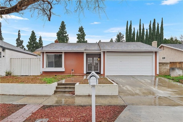 single story home with driveway, an attached garage, and fence