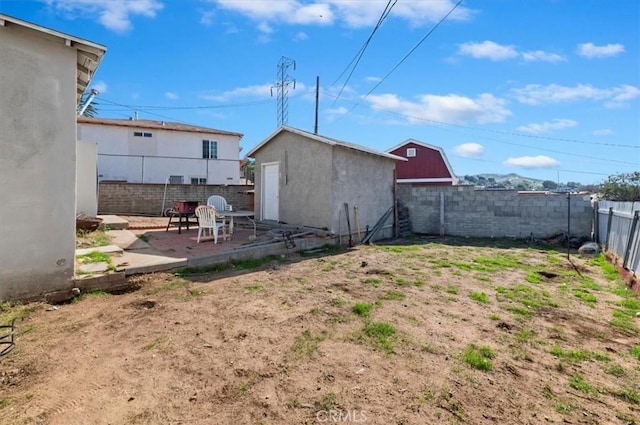 view of yard with a patio, an outdoor structure, and a fenced backyard