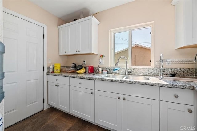 kitchen featuring white cabinetry and a sink