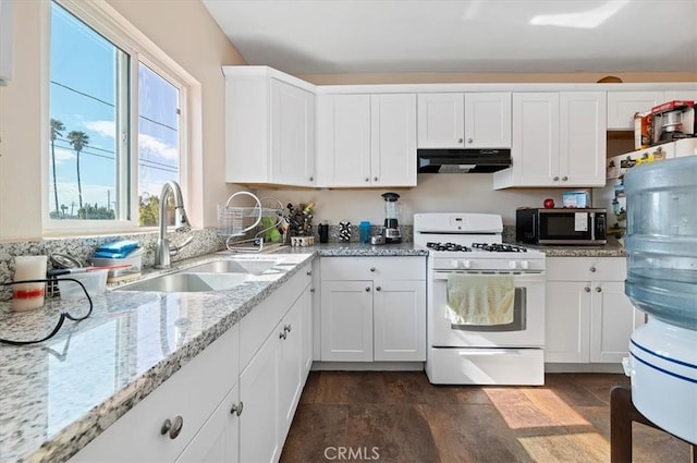 kitchen featuring light stone counters, under cabinet range hood, a sink, white cabinetry, and white range with gas cooktop