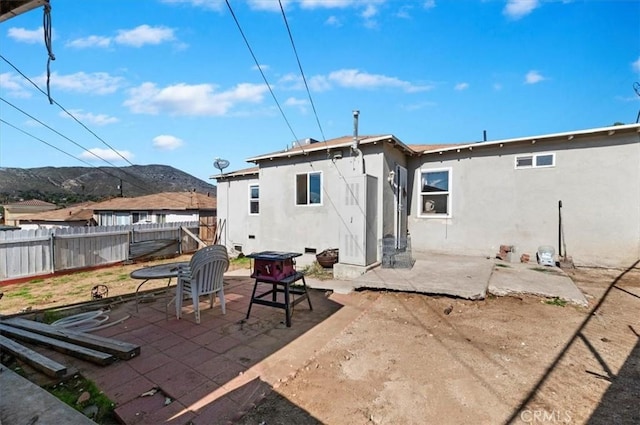 back of property featuring a patio area, a mountain view, a fenced backyard, and stucco siding