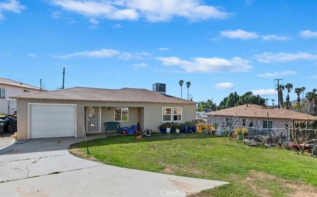 view of front of house with stucco siding, a front yard, fence, a garage, and driveway