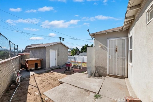 view of patio / terrace with a storage shed, an outdoor structure, and a fenced backyard