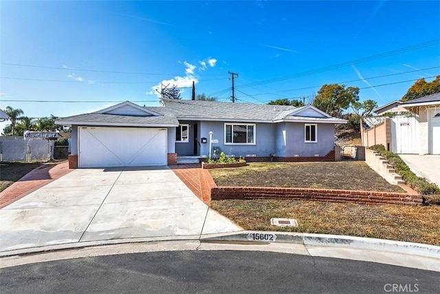 ranch-style house featuring roof with shingles, stucco siding, fence, a garage, and driveway