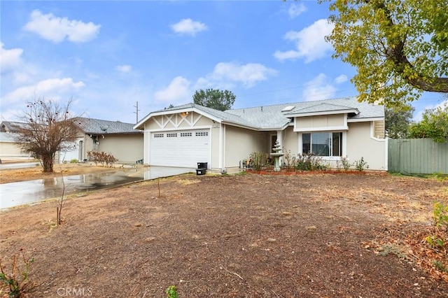 ranch-style home featuring concrete driveway, fence, and an attached garage