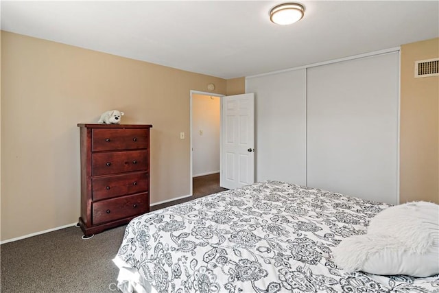 carpeted bedroom with visible vents, baseboards, and a closet