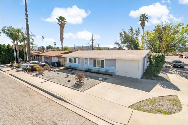 ranch-style house with driveway and stucco siding