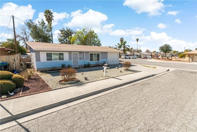 single story home with concrete driveway and fence