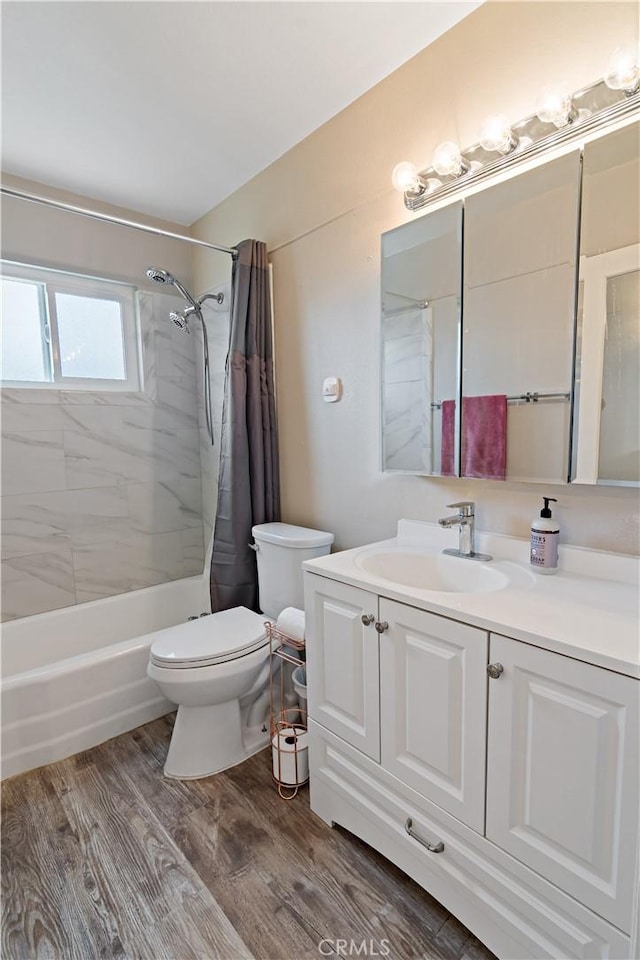 full bath featuring shower / bathtub combination with curtain, wood finished floors, toilet, and vanity