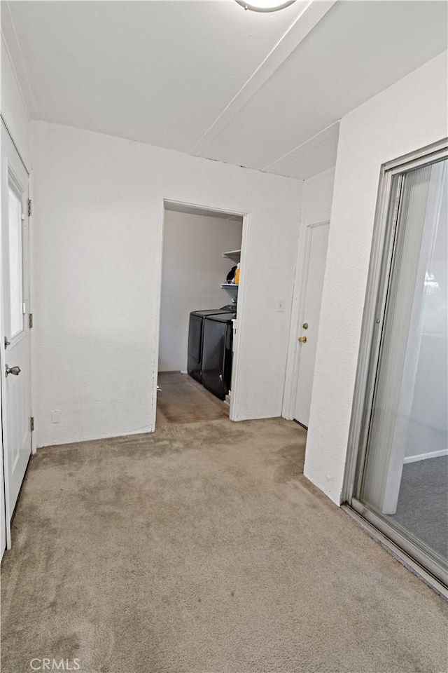 carpeted spare room with separate washer and dryer