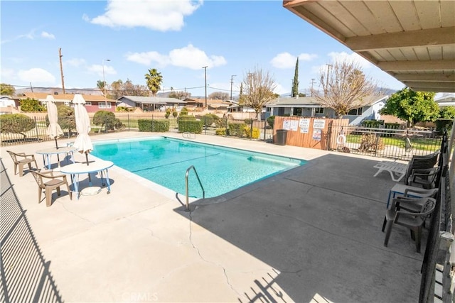 community pool featuring a residential view, a patio, and fence