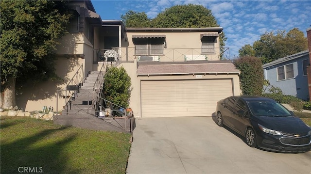 view of front facade featuring a garage, driveway, stucco siding, stairs, and a front yard