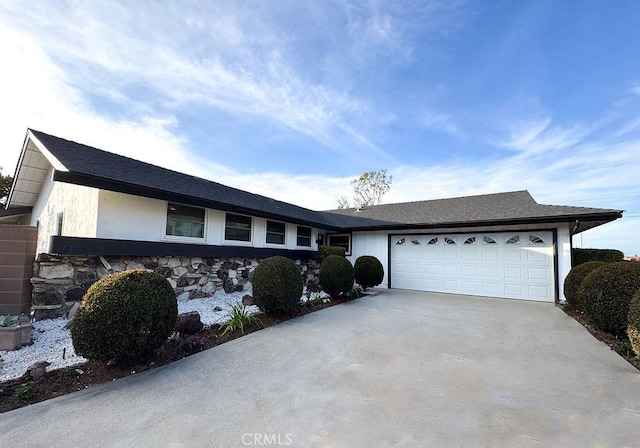 ranch-style house with an attached garage and concrete driveway