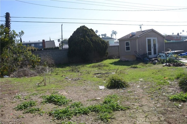 view of yard featuring a fenced backyard and french doors