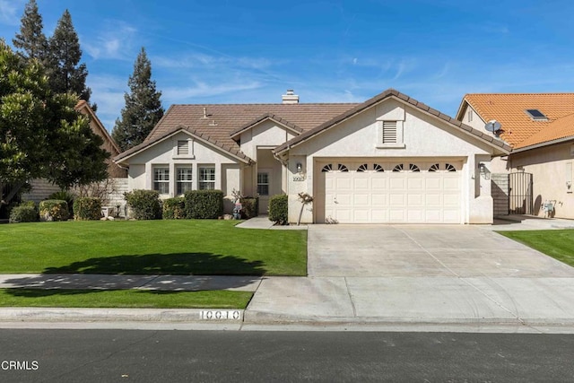 view of front facade with a chimney, stucco siding, a front yard, a garage, and driveway