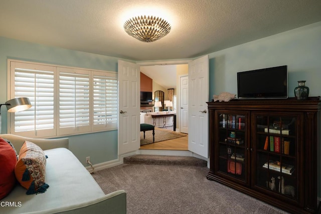 carpeted bedroom featuring a textured ceiling and baseboards