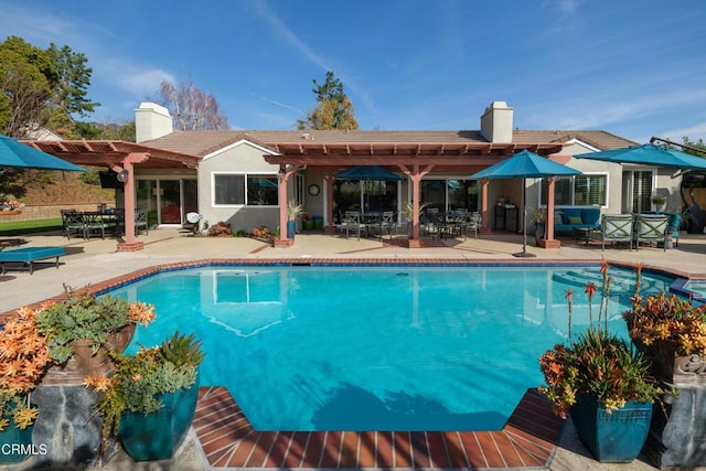 outdoor pool with a patio area and a pergola