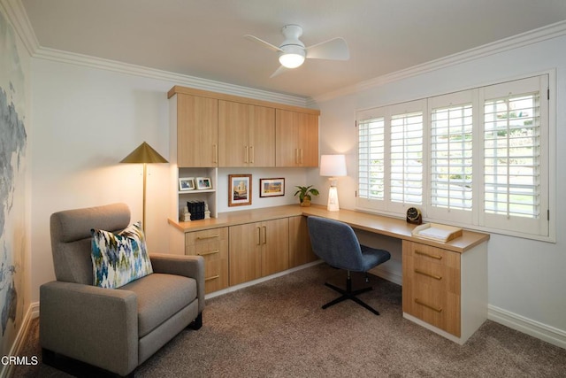 office space featuring carpet, crown molding, ceiling fan, and built in desk