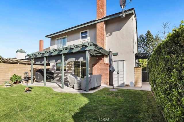 back of property featuring a yard, stucco siding, fence, and a pergola