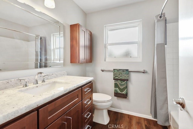 bathroom with toilet, shower / bath combo with shower curtain, vanity, wood finished floors, and baseboards