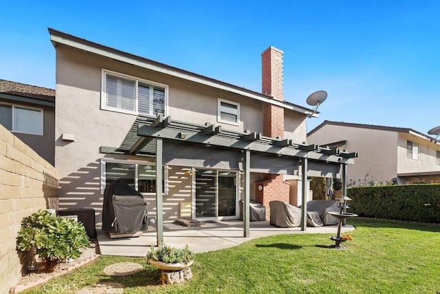 back of property featuring fence, a lawn, stucco siding, a pergola, and a patio area