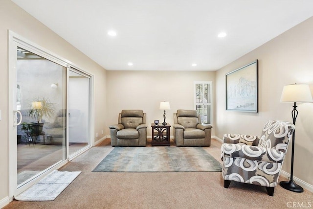 living area featuring baseboards, recessed lighting, and light colored carpet