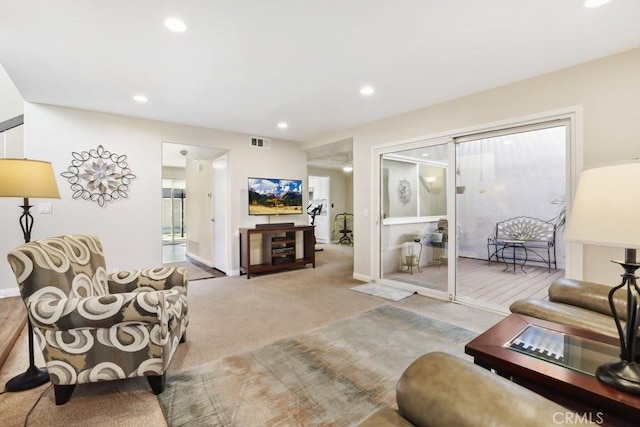 living room with recessed lighting, visible vents, light carpet, and baseboards