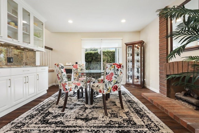 dining room featuring dark wood-type flooring, recessed lighting, a fireplace, and baseboards