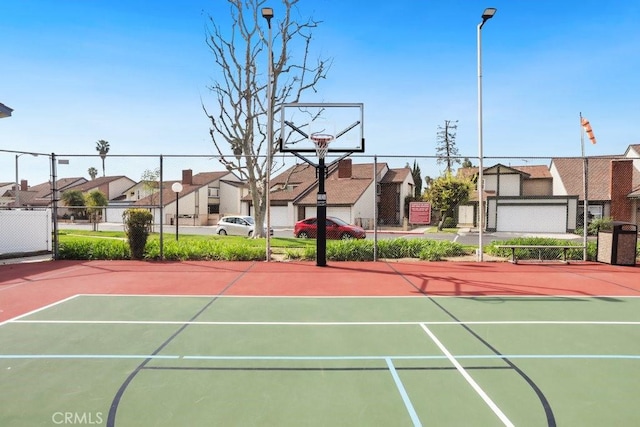 view of sport court with community basketball court, fence, and a residential view