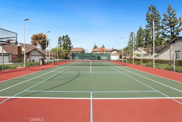 view of sport court featuring community basketball court, fence, and a residential view