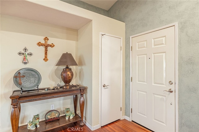 hall with baseboards and wood finished floors