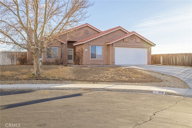 single story home with an attached garage, fence, concrete driveway, a tiled roof, and stucco siding