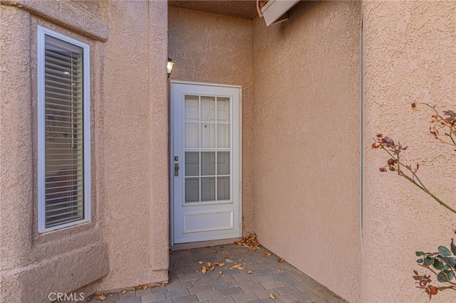 property entrance with a patio area and stucco siding