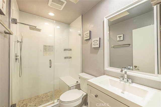 bathroom with toilet, a textured wall, visible vents, and vanity