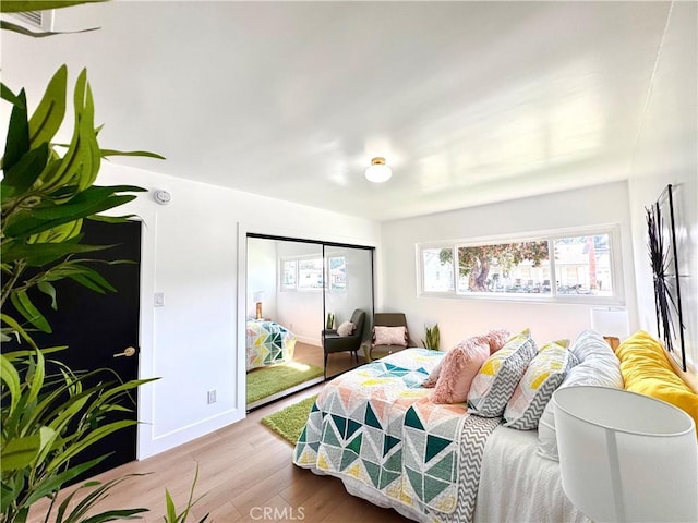 bedroom featuring baseboards, a closet, and light wood-style floors