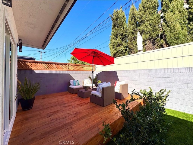 wooden terrace featuring outdoor lounge area and a fenced backyard