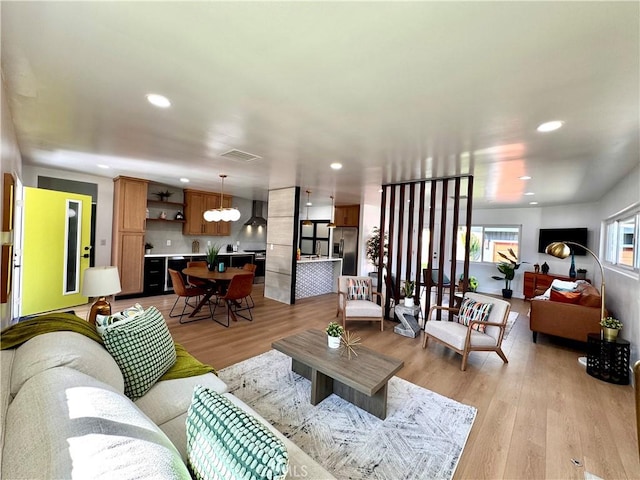 living room with recessed lighting, visible vents, and light wood-style flooring