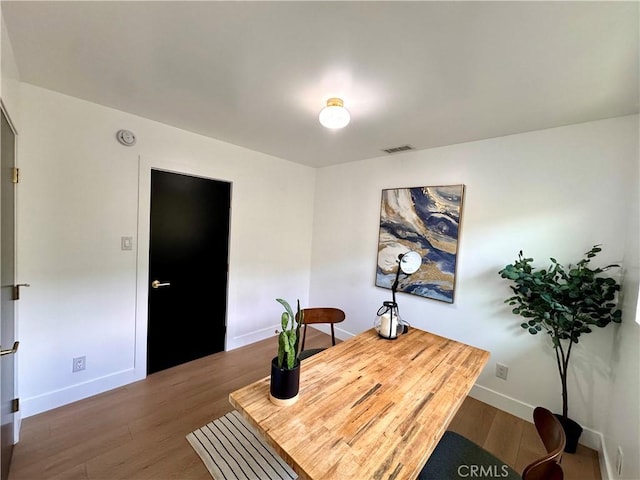 office space with wood finished floors, visible vents, and baseboards