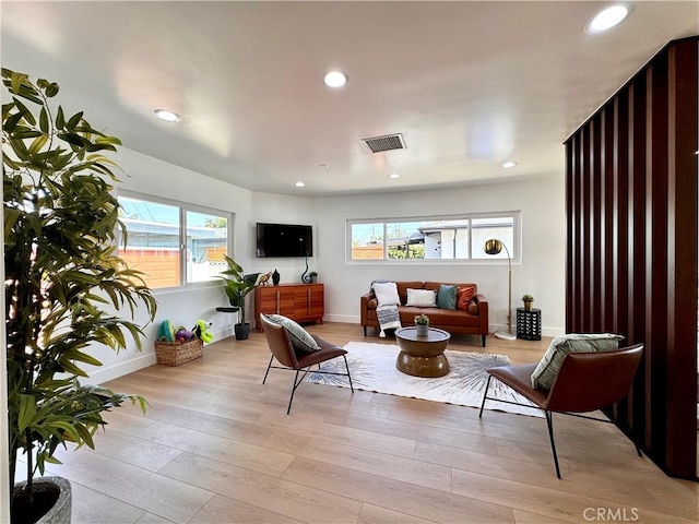 sitting room with light wood-type flooring, visible vents, baseboards, and recessed lighting