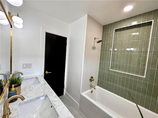 full bath featuring tile patterned floors, a sink, shower / tub combination, and double vanity