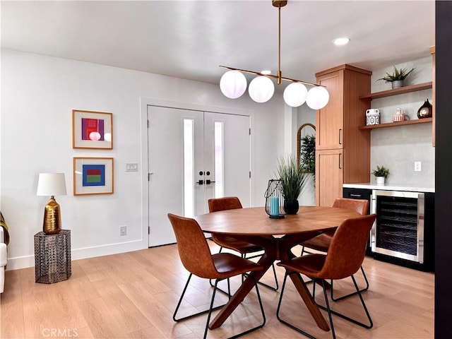 dining space with wine cooler, french doors, recessed lighting, light wood-type flooring, and baseboards