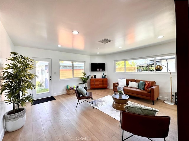 living area featuring baseboards, recessed lighting, visible vents, and light wood-style floors