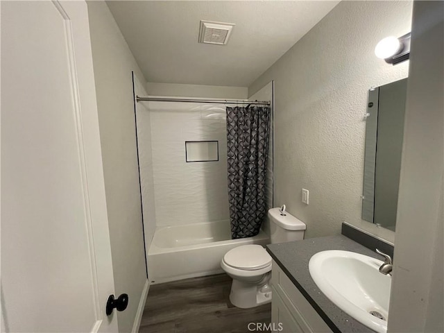 bathroom with visible vents, toilet, shower / tub combo, vanity, and wood finished floors