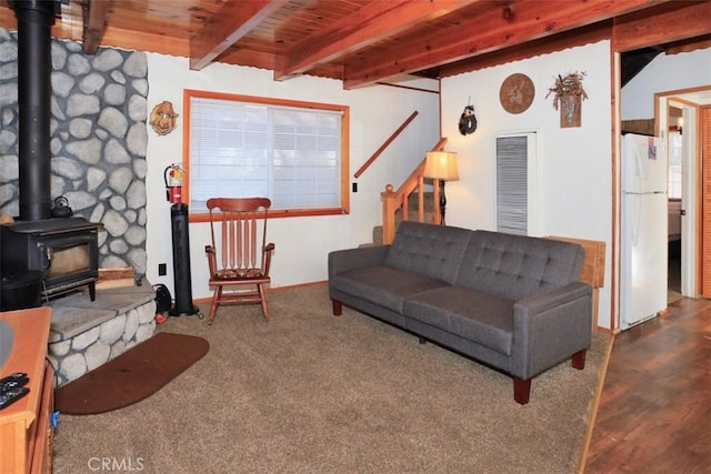 living room featuring wood ceiling, stairway, wood finished floors, a wood stove, and beam ceiling