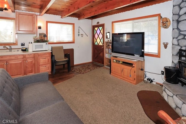 living area with beamed ceiling, wood ceiling, and baseboards