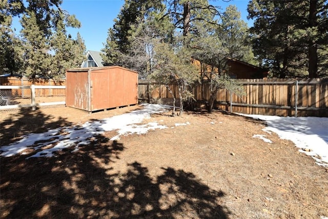 view of yard with a fenced backyard, an outdoor structure, and a shed