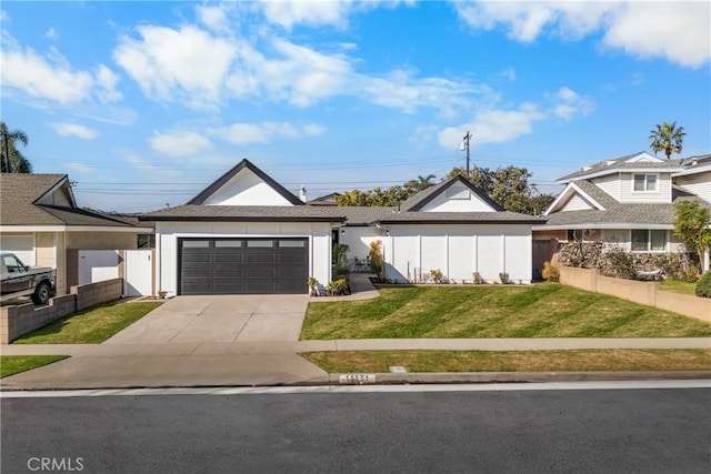 view of front of house featuring driveway, an attached garage, fence, and a front yard