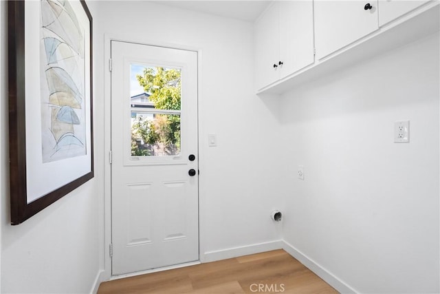 laundry room with light wood finished floors, hookup for an electric dryer, cabinet space, and baseboards