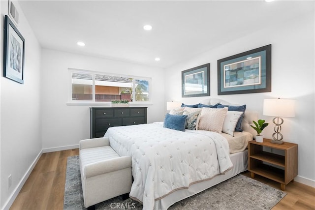 bedroom with baseboards, visible vents, wood finished floors, and recessed lighting